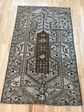 Load image into Gallery viewer, Vintage Anatolian Milas rug 4’2” x 6’11” — full rug on wood floor with geometric borders