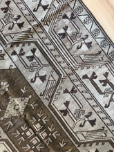 Load image into Gallery viewer, Vintage Anatolian Milas rug 4’2” x 6’11” — angled close-up of dark medallion and patterned border
